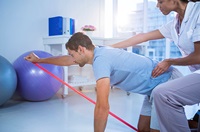man stretching on the floor guided by a physical therapist